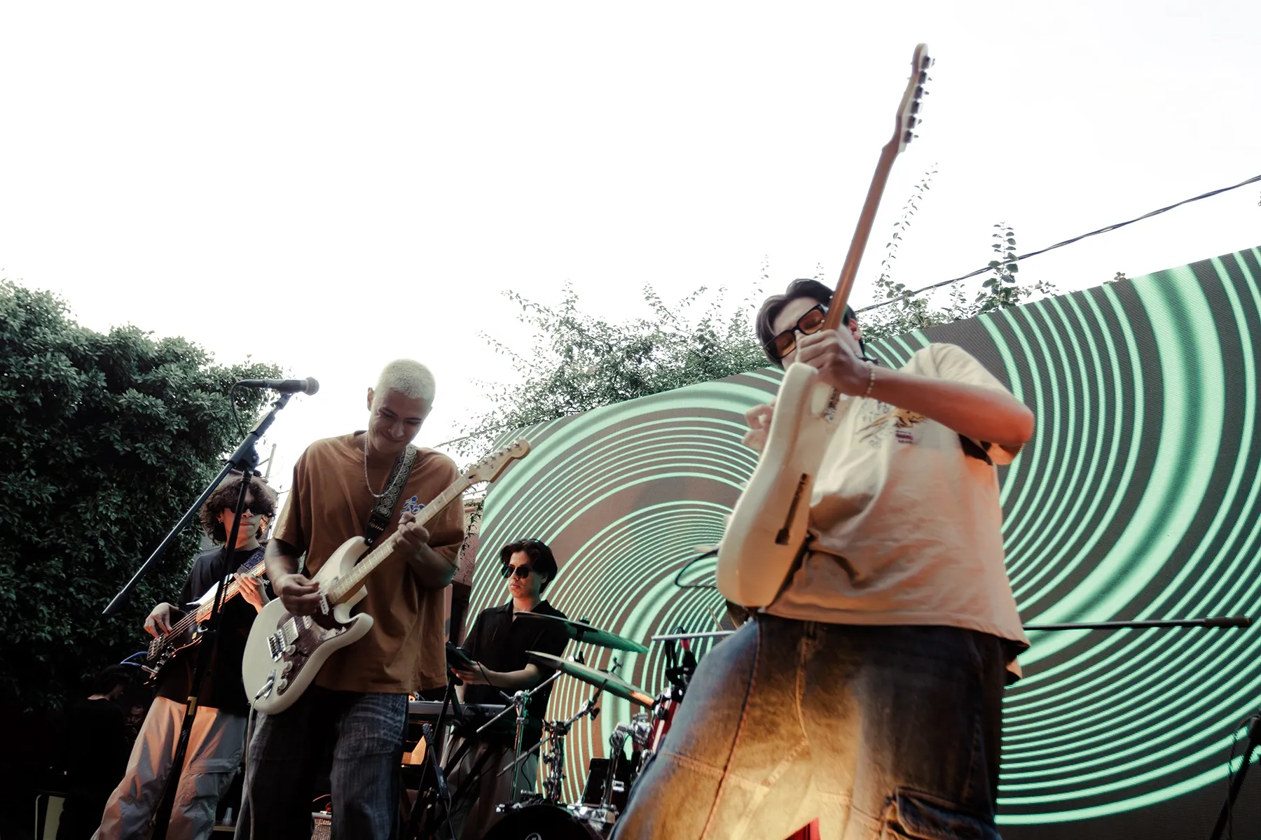 Banda tocando frente a una pantalla con espiral luminosa